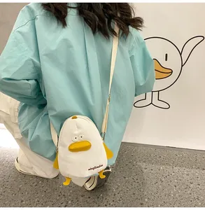 Detail view of the cute duck canvas crossbody bag shown on a model against a white wall