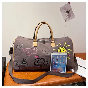 Vue détaillée du sac de voyage en toile grise avec graffiti et tablette de référence