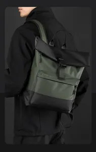 Side view of dark green roll-top waterproof business backpack on model in black jacket