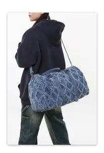 Détails du sac de voyage en denim bleu avec texture matelassée et bandoulière