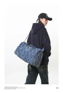 Vue détaillée du sac de voyage en denim bleu foncé avec matelassage et bords effilochés