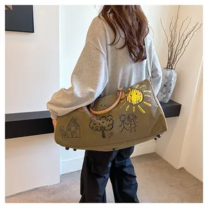 Vue détaillée du grand sac de voyage en toile olive avec graffitis et bandoulière réglable