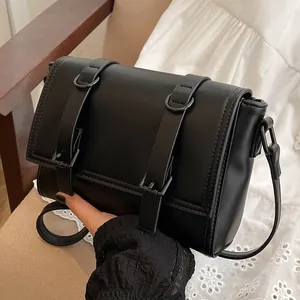 Chique zwarte vintage crossbody tas met decoratieve gespen en een matte afwerking