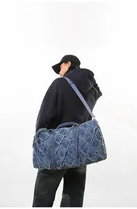 Détail du sac de voyage en denim bleu avec texture matelassée et franges vintage