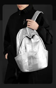 Detail of silver geometric patchwork PU leather backpack with metallic quilted finish