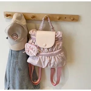 Detail van roze geplooide nylon rugzak met ruches en hartvormige hanger