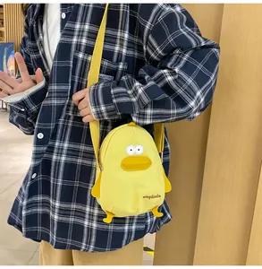 Detail of cute yellow duck canvas crossbody bag with adjustable strap on a model