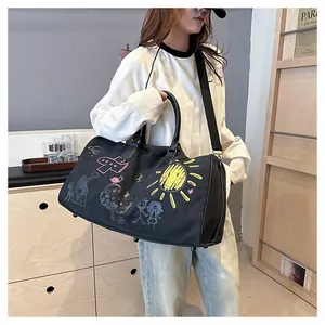 Détail du sac de voyage en toile noire avec des illustrations de soleil jaune et de cœur rose