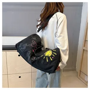 Vue arrière du mannequin portant un grand sac de voyage graffiti aux imprimés colorés