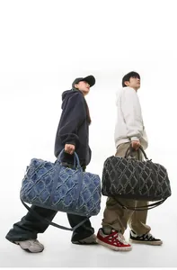 Détail du sac de voyage matelassé en denim avec bords effilochés et bandoulière réglable