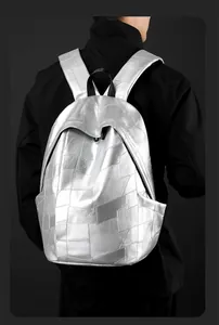 Silver geometric patchwork backpack showing modern metallic texture on a model's back