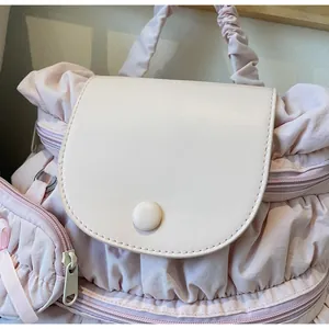 Detail of soft pink pleated nylon fabric with light leather flap and round button closure