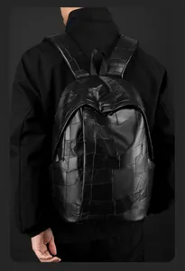 Detailed view of black PU leather patchwork backpack with textured panels and wide straps