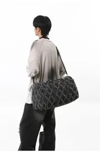 Gros plan sur la texture denim vieilli avec motif de losanges sur un grand sac noir