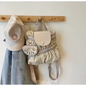 Detail van beige geplooide nylon rugzak met een bijpassende hartvormige mini-portemonnee