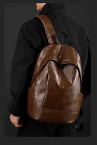 Rear view of brown PU leather backpack with geometric patchwork design on model