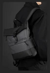 Rear view of model wearing a waterproof roll-top business backpack with matte finish