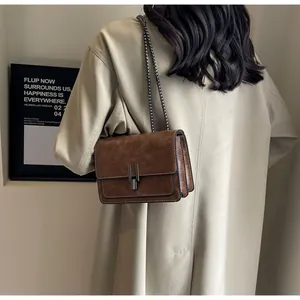 Brown retro chain bag worn over a beige coat showing a stylish crossbody look