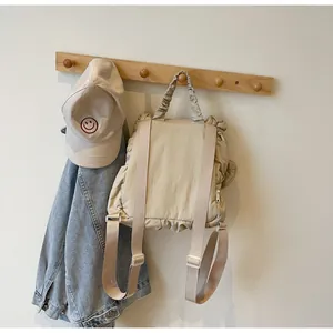 Detail view of the beige pleated nylon backpack back structure and side zipper design