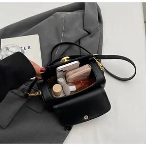 Detail view of black leather cylinder bag interior showing ample storage and gold hardware