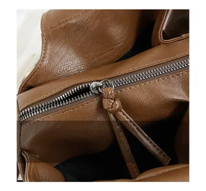 Détail rapproché d'un sac cabas en cuir marron avec fermeture éclair en métal argenté