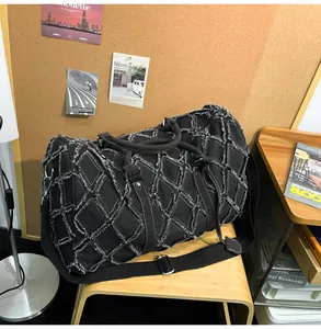 Détail du sac de voyage matelassé noir avec franges blanches et bandoulière réglable