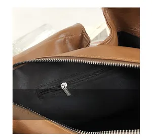 Détail de l'intérieur du sac en cuir marron avec doublure noire et poche zippée pratique
