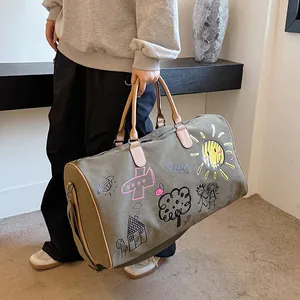 Sac de voyage en toile vert olive avec graffiti colorés et poignées en cuir marron