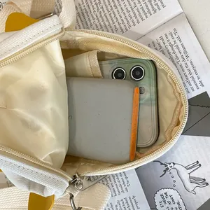 Canvas crossbody bag showing spacious interior for phone and power bank with zip