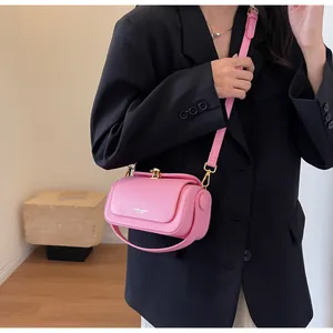 Detail of pink leather flap crossbody bag with golden lock on black suit background