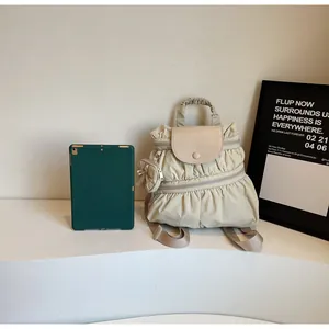 Detail of light beige pleated nylon backpack with side coin pouch and top handle