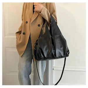 Détail d'un grand sac cabas noir en cuir plissé mat avec bandoulières amovibles
