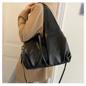 Détail d'un grand sac cabas noir à texture plissée avec bandoulière réglable pratique