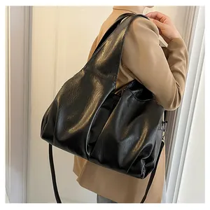 Gros plan d'un grand cabas en cuir PU noir sur modèle avec texture souple et rétro