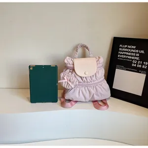 Detailed view of pink pleated mini backpack with detachable round bow coin purse and top flap