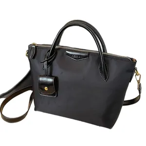 Black high-density nylon tote bag with gold hardware and removable shoulder strap