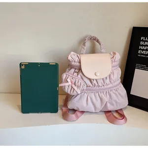 Detailed view of light pink pleated nylon backpack with a matching round coin purse