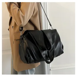 Vue détaillée du grand sac cabas noir avec texture en cuir souple et design plissé