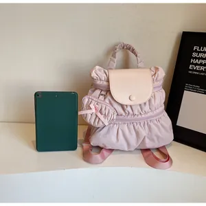 Detail of light pink pleated backpack with matching ribbon charm and top handle