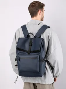 Detail van een marineblauwe waterbestendige rugzak met roll-top en gespsluiting