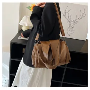 Vue détaillée du grand sac cabas rétro marron foncé avec plis souples et bandoulière