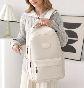 Minimalist cream white backpack with spacious main compartment and front pocket worn by model