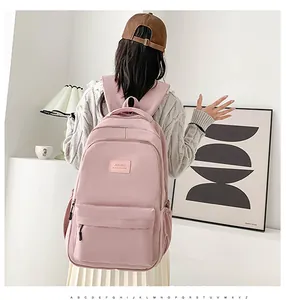 Detail view of pink backpack textured fabric and secure front zipper pocket with logo