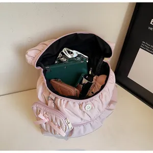 Detail of pink pleated backpack interior showing large capacity for tablet and items