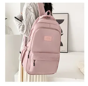 Detailed side view of pink waterproof backpack with leather label and layered zip pockets