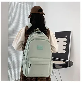 Close-up of mint green lightweight backpack with multi-compartments on a lifestyle model