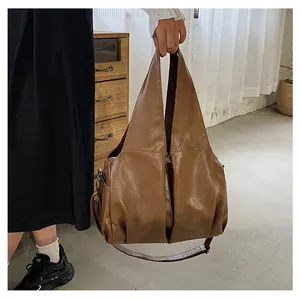 Détail du sac cabas marron vintage montrant la texture en similicuir et plis souples
