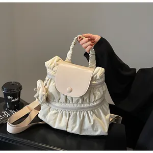 Detail of off-white pleated nylon backpack with matching mini coin purse and soft handle