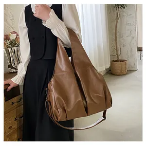 Détail du sac cabas en cuir souple marron montrant la texture lisse et les fixations