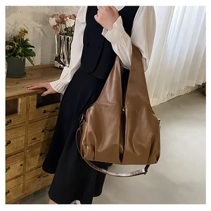 Grand sac cabas marron rétro porté par un mannequin dans un cadre intérieur minimaliste